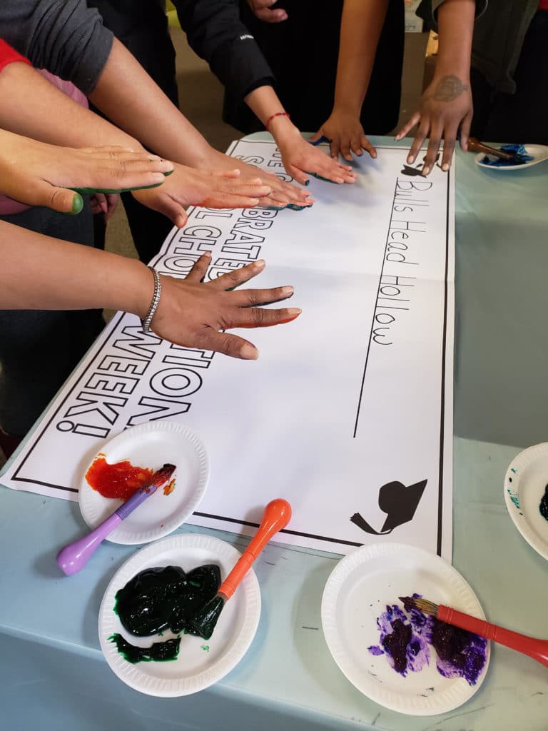 students-decorate-banner-with-handprints