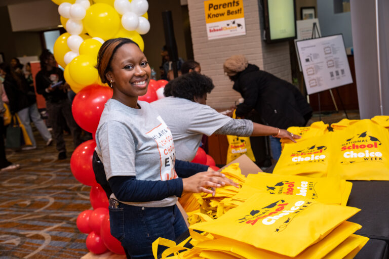 A volunteer helps hand out swag bags at a school fair in Atlanta