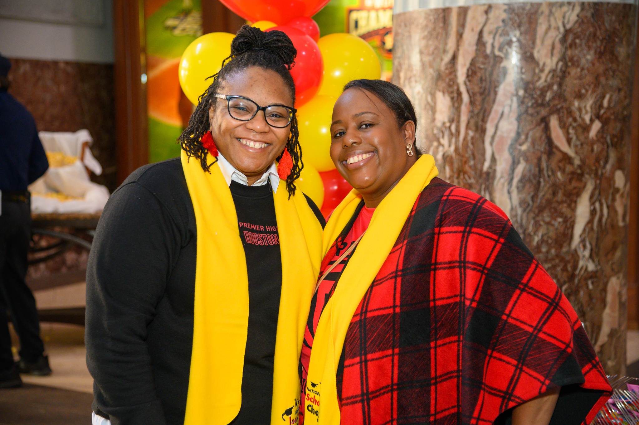 Two teachers wearing scarves smile