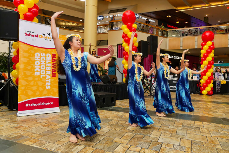 A group of four dancers performs at an event in a mall