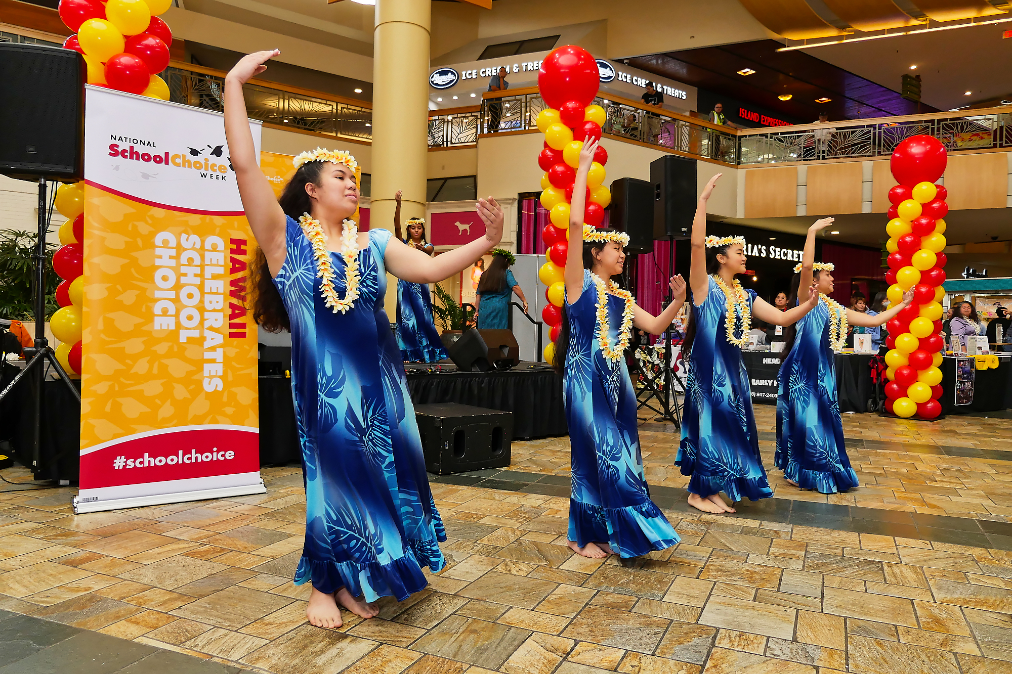 A group of four dancers performs at an event in a mall
