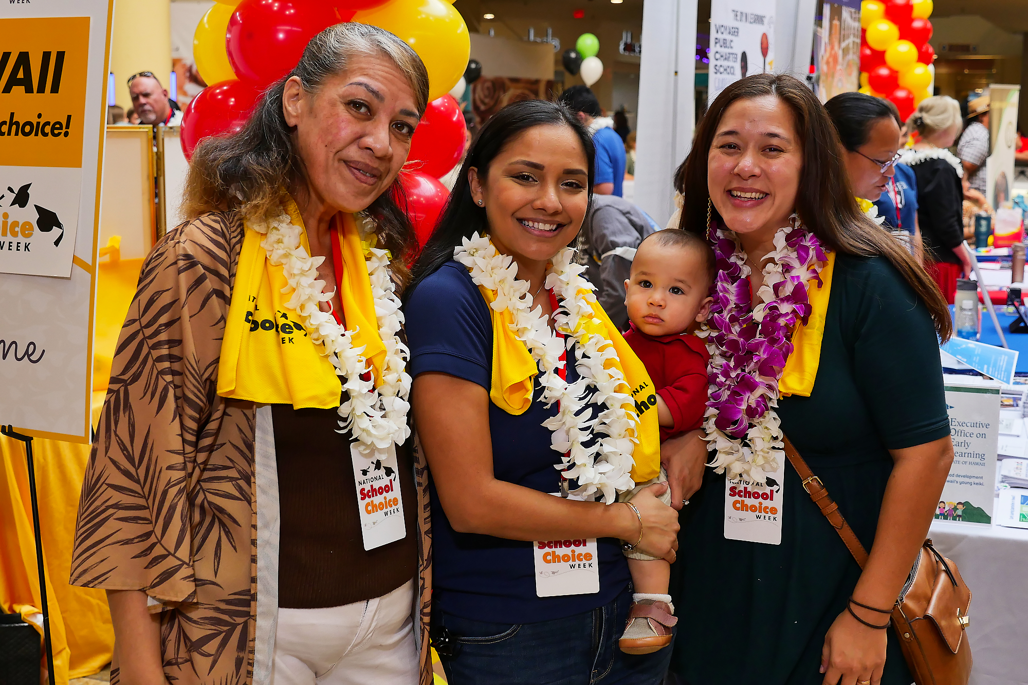 A multi-generational family smiles for a photo at a school fair