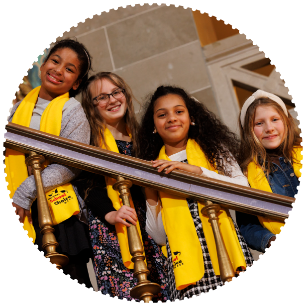 A group of students wearing scarves smile for the camera at a capitol event