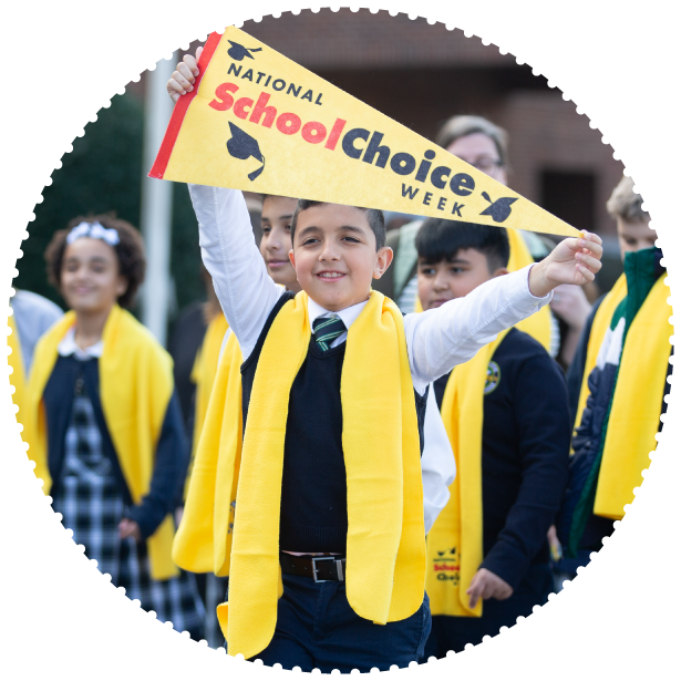 A student wearing a scarf holds up a School Choice Week pennant