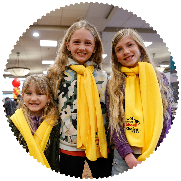 Three students wearing School Choice Week scarves smile