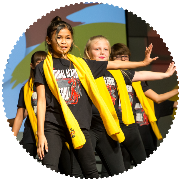 A group of students wearing School Choice Week scarves dance at an event