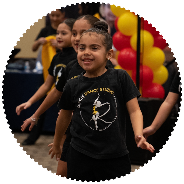 A group of young students dance at an event